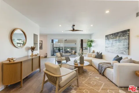 a living room with fireplace furniture and a large window