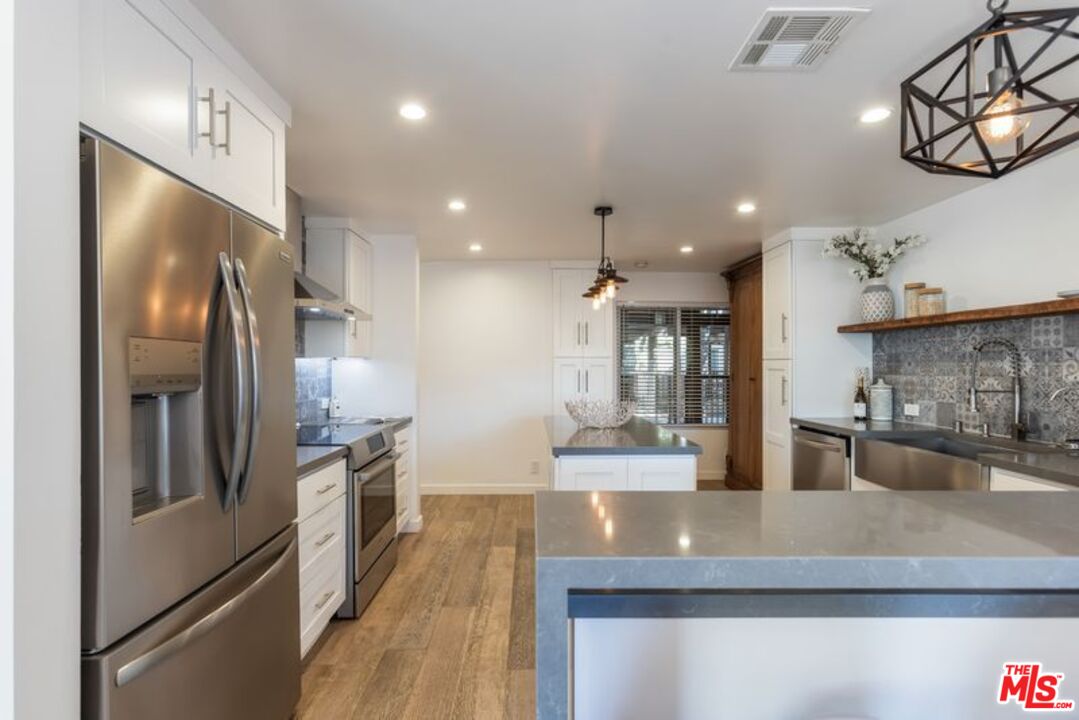 4300 Vía Dolce, Unit 102 Marina del Rey, CA 90292 - Photo 11 of 39 a kitchen with stainless steel appliances granite countertop a refrigerator a sink and a stove