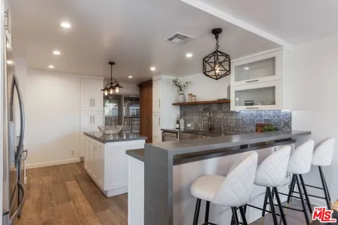 a kitchen with stainless steel appliances granite countertop a sink and a refrigerator