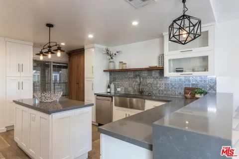 a kitchen with granite countertop a sink and a stove top oven with granite countertops