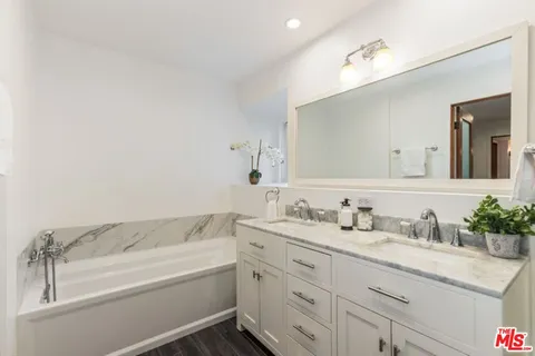 a bathroom with a granite countertop sink mirror and bathtub