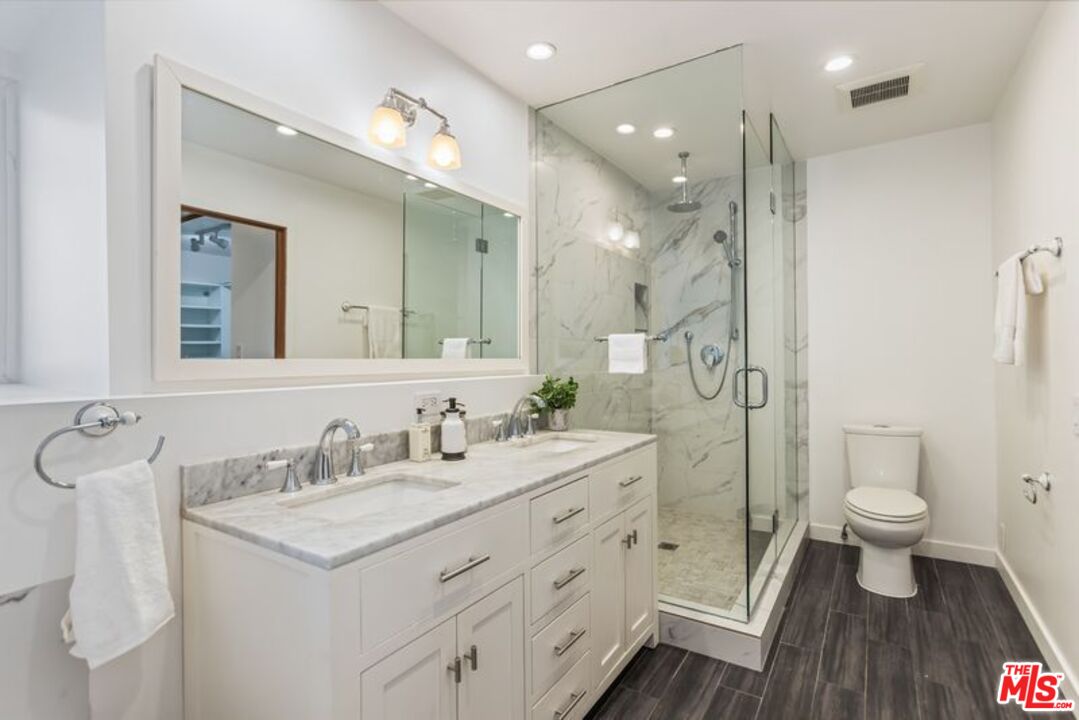 4300 Vía Dolce, Unit 102 Marina del Rey, CA 90292 - Photo 27 of 39 a bathroom with a double vanity sink toilet a mirror and shower