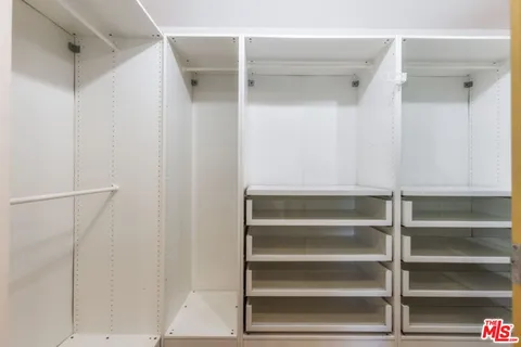 a view of walk in closet with empty racks