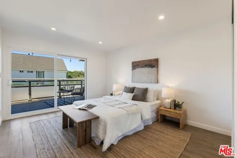 a bedroom with a bed and a view of kitchen