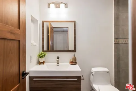 a bathroom with a sink vanity mirror and toilet