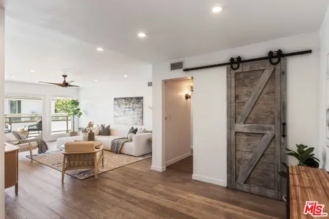 a living room with furniture and a refrigerator