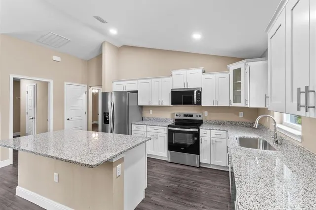 a kitchen with stainless steel appliances granite countertop a sink stove and refrigerator