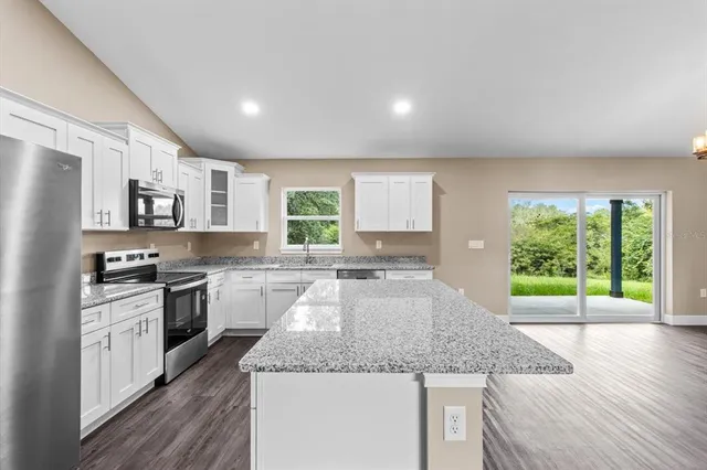 a kitchen with stainless steel appliances granite countertop sink stove and refrigerator