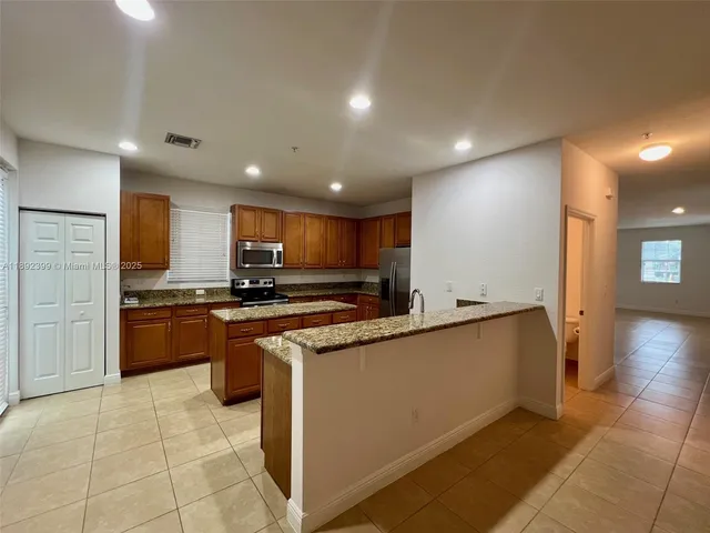 a large kitchen with stainless steel appliances lots of counter top space and cabinets