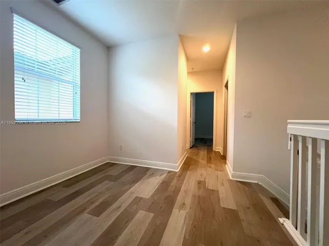 a view of a room with wooden floor and a window