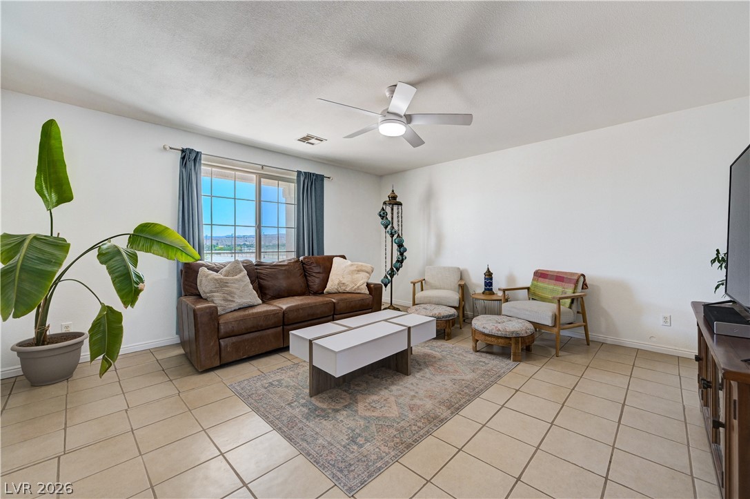 1272 Liston Avenue Logandale, NV 89021 - Photo 9 of 61 Sun-filled living area features tile flooring, a large window, and a ceiling fan.