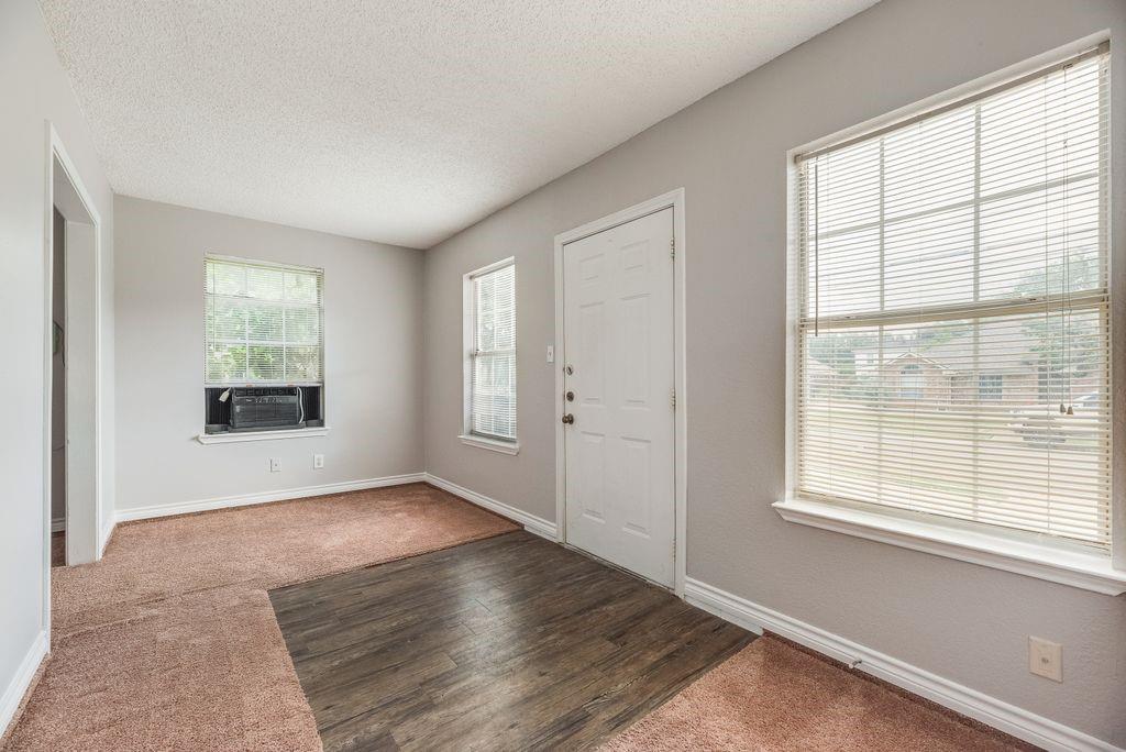 5610 Eagle Rock Road Arlington, TX 76017 - Photo 26 of 33 Entryway featuring a white paneled door, wood-finish flooring, and carpeted area