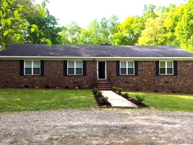a front view of a house with a garden and yard