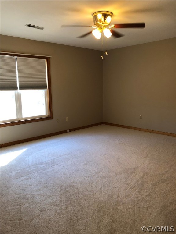 7721 Deer Run Road New Kent, VA 23124 - Photo 15 of 22 an empty room with a chandelier fan and windows