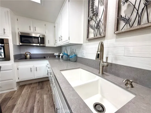 a kitchen with granite countertop a sink a stove and cabinets