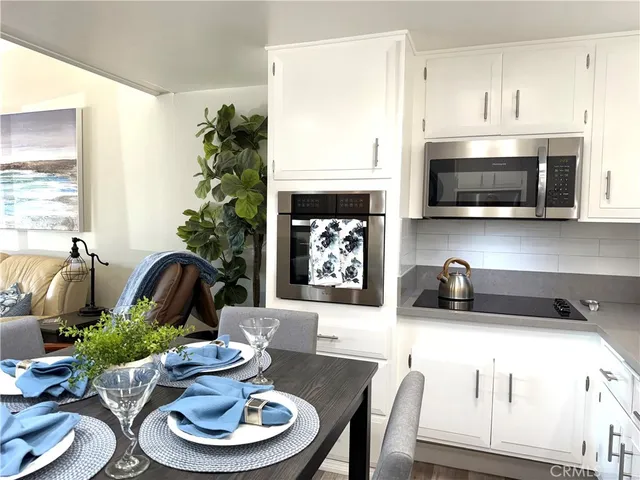 a kitchen with a stove a microwave and living room