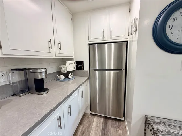 a kitchen with a refrigerator sink and cabinets