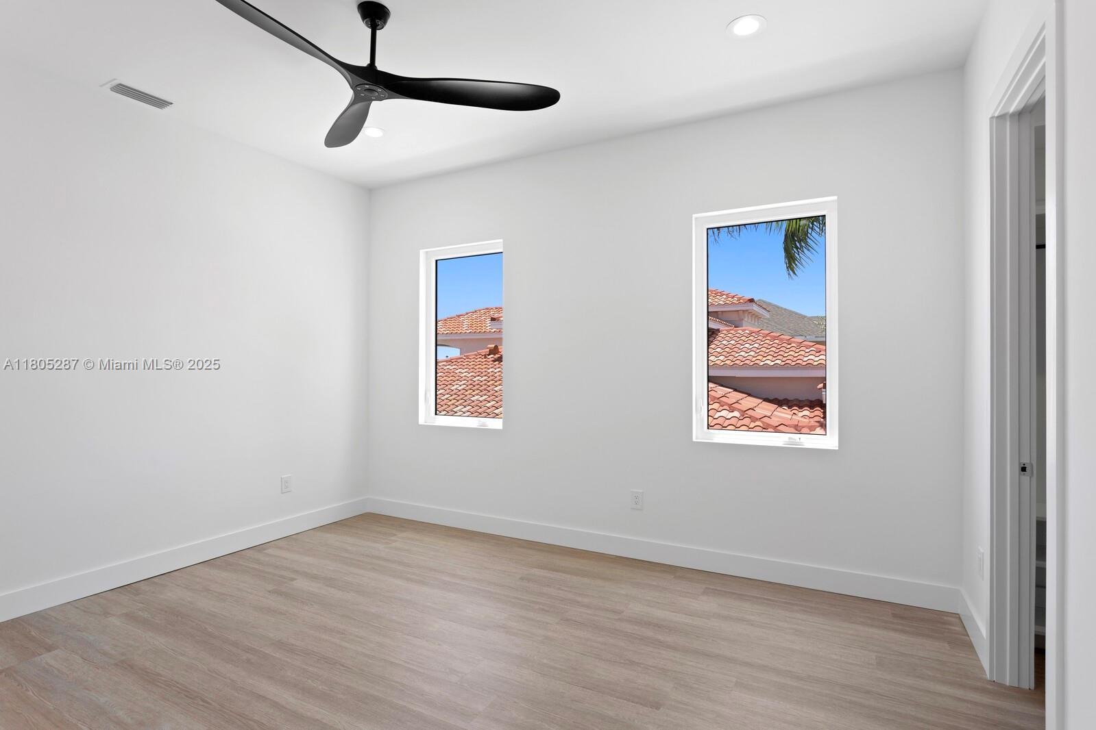 17059 Dolphin Drive St. Petersburg, FL 33708 - Photo 18 of 70 a view of an empty room with wooden floor and a window