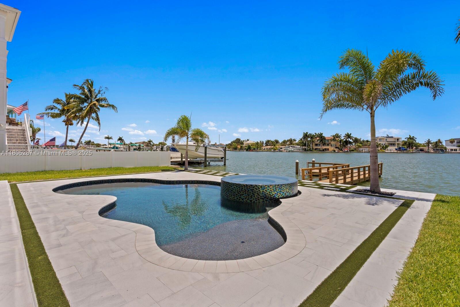 17059 Dolphin Drive St. Petersburg, FL 33708 - Photo 44 of 70 a view of a swimming pool with a table and chairs