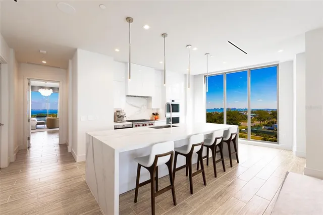 a kitchen with stainless steel appliances kitchen island a sink and a refrigerator