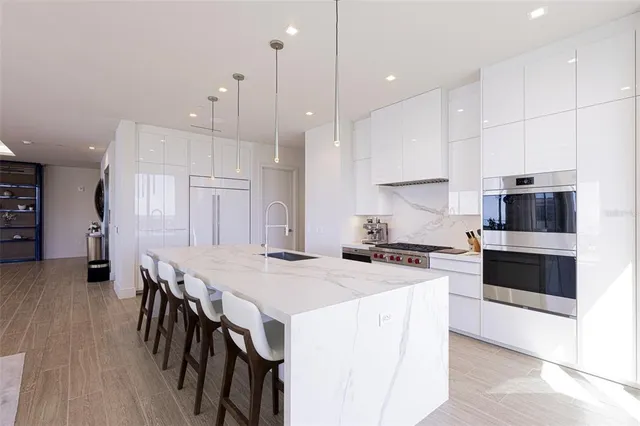a large kitchen with stainless steel appliances granite countertop a lot of counter space and wooden floor