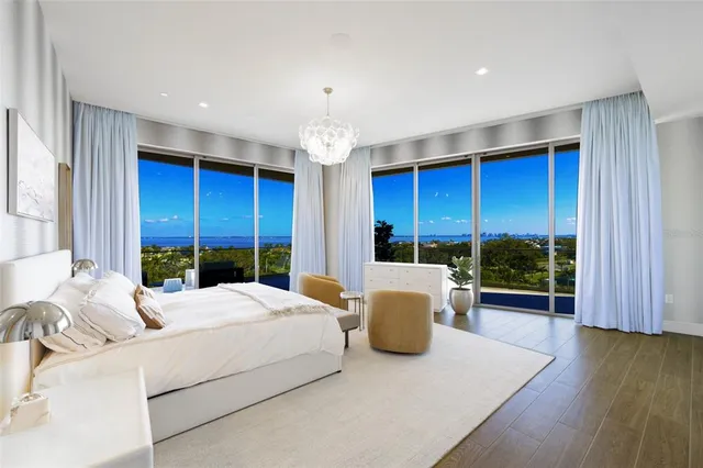 a bedroom with a large bed and a chandelier