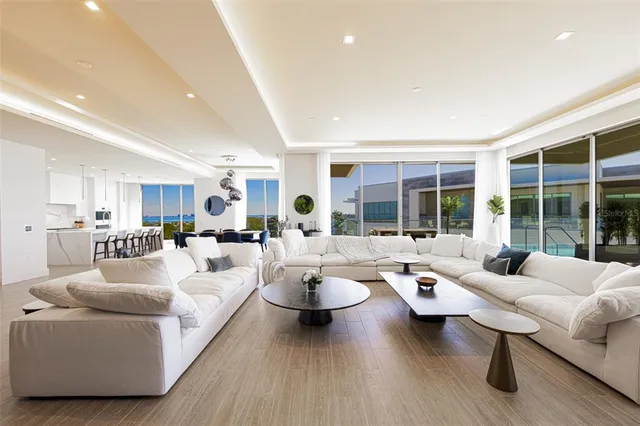 a living room with furniture kitchen view and large windows