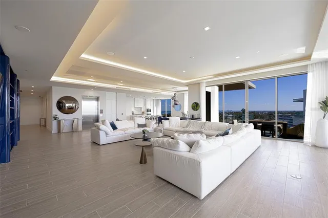a living room with furniture kitchen view and large windows