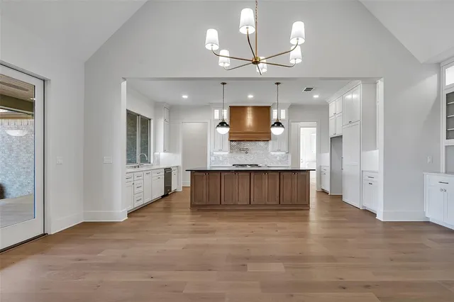 a large kitchen with granite countertop a large counter top appliances and cabinets