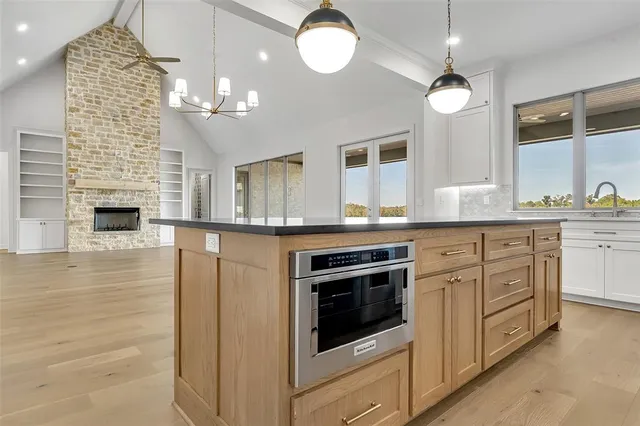 an empty room with wooden floor and a fireplace