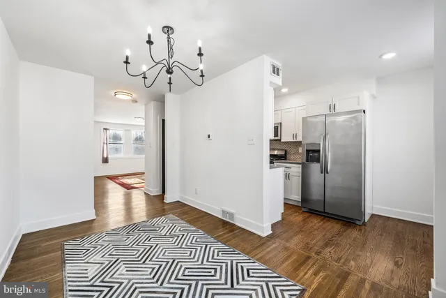 a view of a kitchen with refrigerator and wooden floor