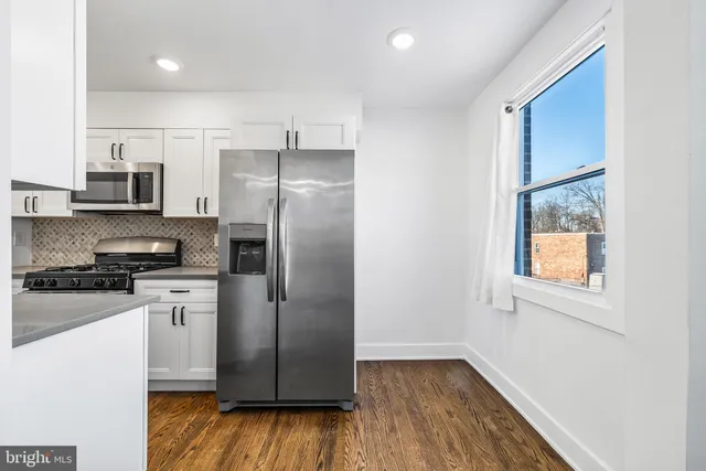 a kitchen with stainless steel appliances a refrigerator sink and microwave
