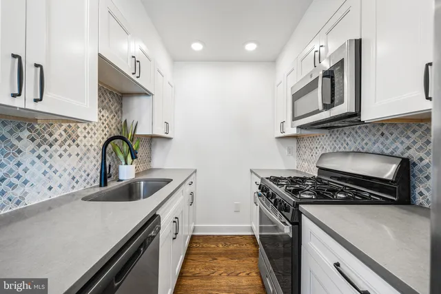 a kitchen with stainless steel appliances granite countertop a sink a stove and a microwave