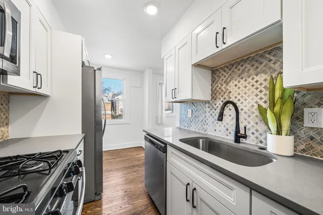 a kitchen with sink a stove and cabinets