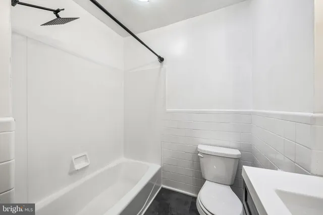 a white toilet sitting next to a bath tub