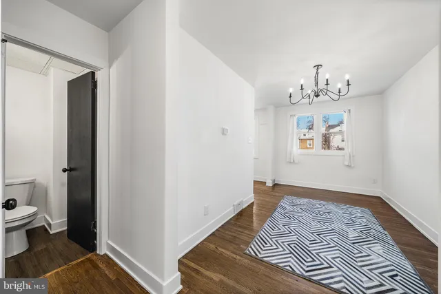 a view of a bedroom with wooden floor and bathroom