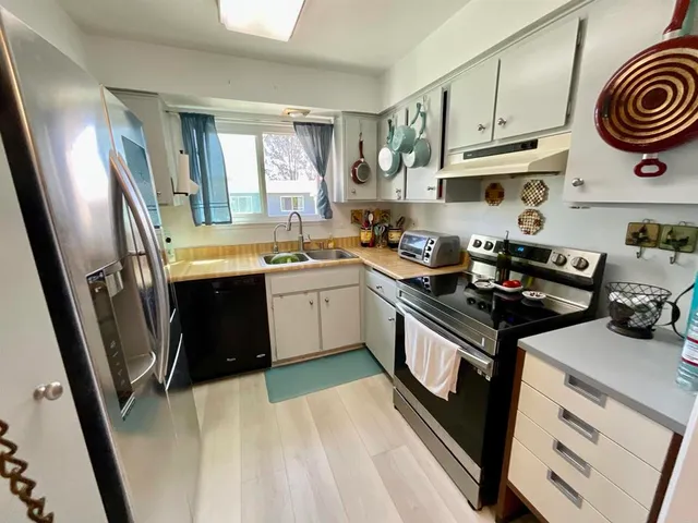 a kitchen with stainless steel appliances granite countertop a sink stove and cabinets