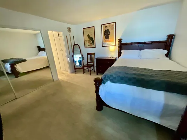 a bedroom with a bed chair and a view of living room