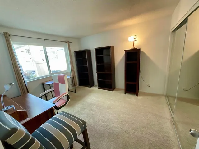a view of a bedroom with furniture and window