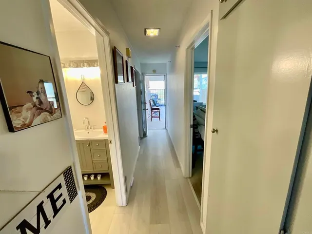 a view of a hallway with wooden floor and windows