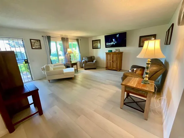 a living room with furniture and a flat screen tv with wooden floor