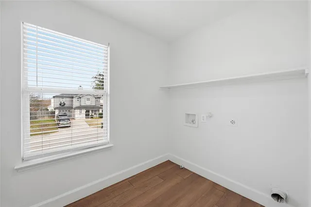 a view of a small space with wooden floor and a window