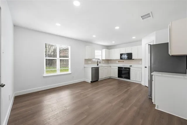 a view of kitchen with granite countertop cabinets and refrigerator