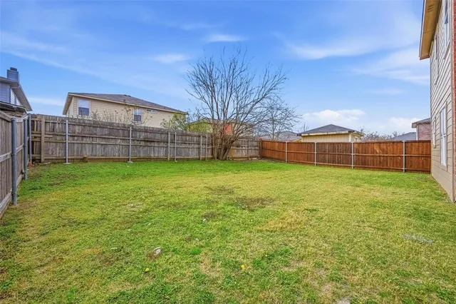 a view of a green field with wooden fence