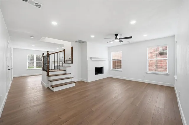 a view of empty room with wooden floor and fireplace