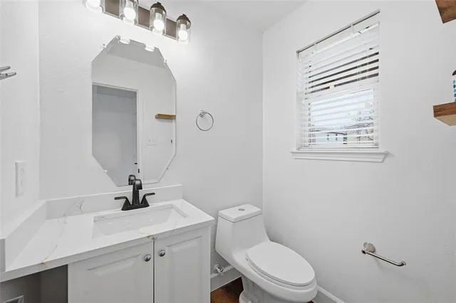 a bathroom with a sink a toilet and mirror