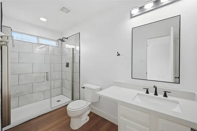 a bathroom with a sink a toilet and shower