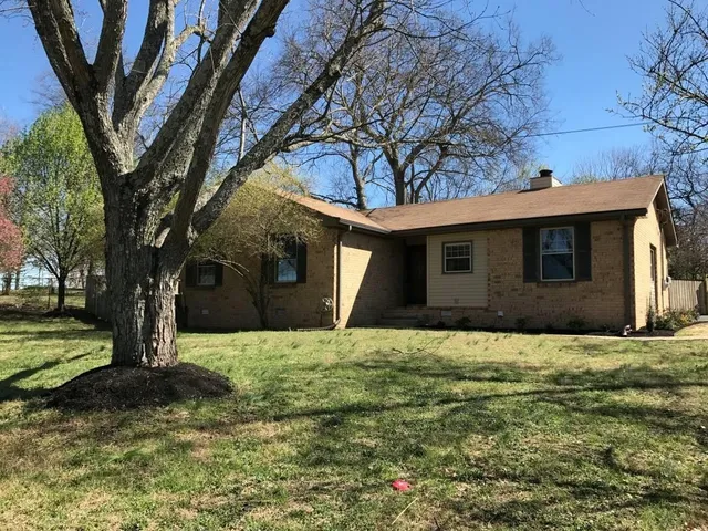 a house that has a big yard with large trees