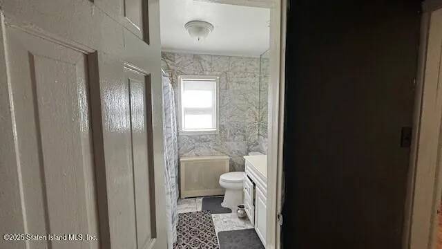 a bathroom with a granite countertop toilet and a shower