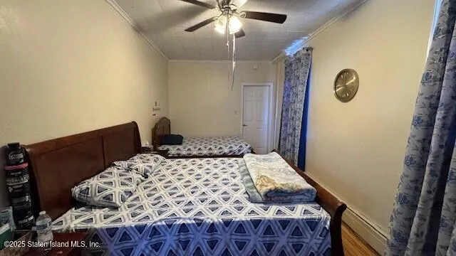 a bedroom with a bed and dresser with wooden floor